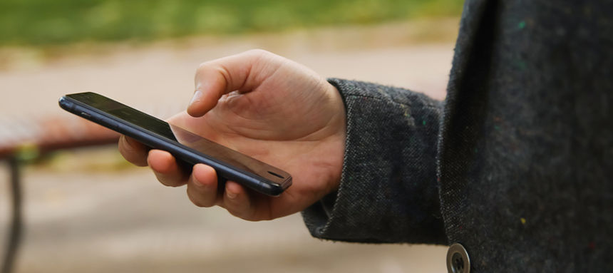 Mann bezahlt per Handy